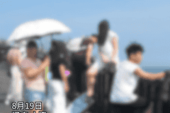 多位游客翻越滨海东路护栏,站在悬崖上拍照打卡