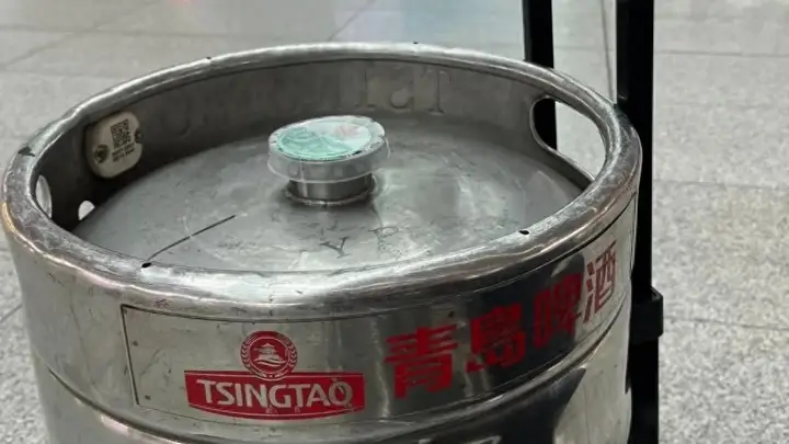 青岛火车站好多人拖着铁桶扎啤返乡,今夏青岛最硬核伴手礼